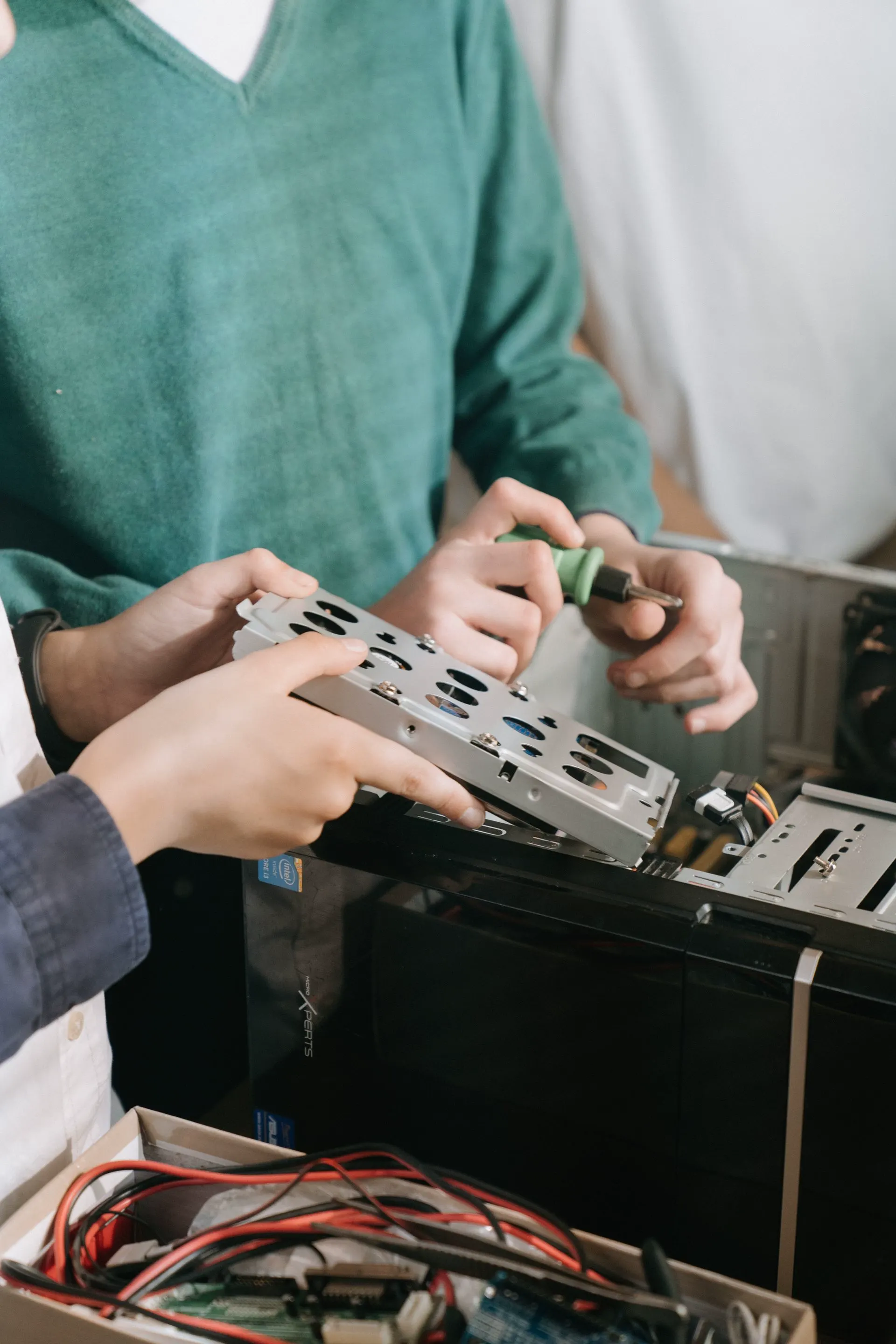 Technicians repairing business computer hardware with hand tools